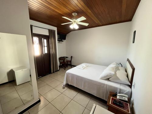 een slaapkamer met een bed en een plafondventilator bij Pousada Vila do Imperador in Diamantina
