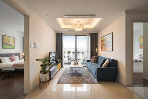 un salon avec un canapé bleu et une télévision dans l'établissement Troy House - Vinhomes Dcapitale - Cau Giay, à Hanoï