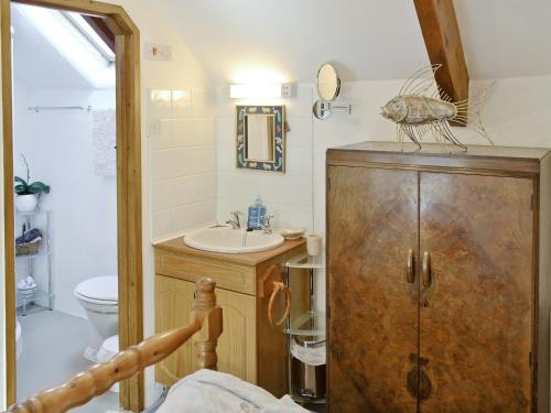 Rock Barn في Saint Issey: حمام مع حوض ومرحاض ومرآة