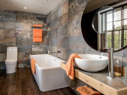 a bathroom with a tub and a sink and a toilet at Willow in Gatehouse of Fleet