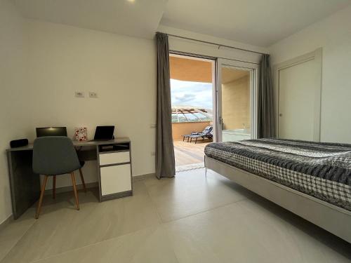 a bedroom with a bed and a desk and a window at Crabonaxa Suite Appartment in Villasimius