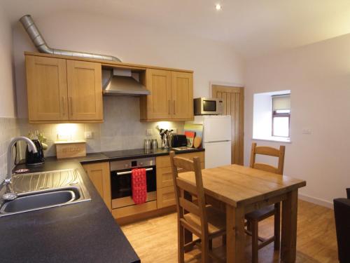 a kitchen with wooden cabinets and a wooden table with a wooden table at Seion - Hw7575 in Llanddeiniolen