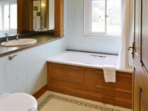 a bathroom with a tub and a sink and a toilet at Leatheswater in Thirlmere