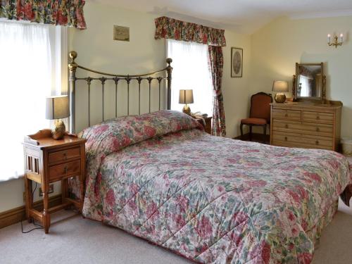 a bedroom with a bed and a dresser and window at Leatheswater in Thirlmere