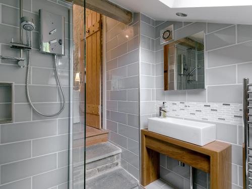 a bathroom with a sink and a shower at Waterfall Wood Cottage in Patterdale