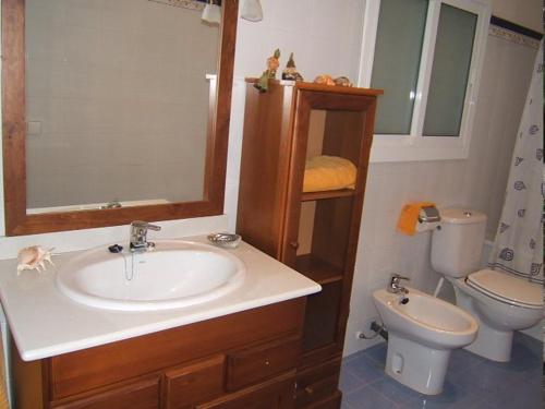 ein Badezimmer mit Waschbecken, Toilette und Spiegel in der Unterkunft Casa Bellissima in Calafat