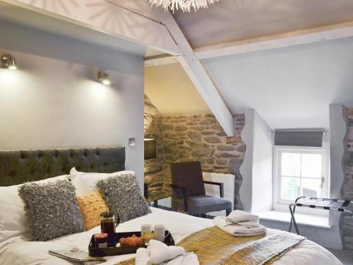 a bedroom with a large bed and a stone wall at Ivy Bush Cottage in Llanddewi-Brefi