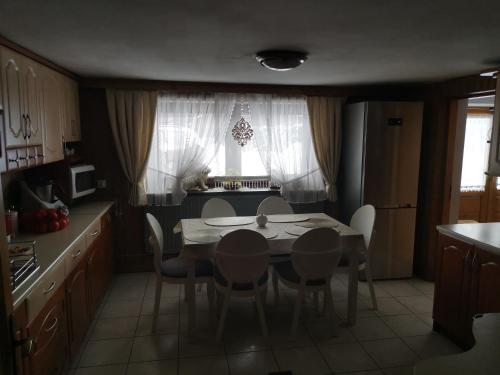 a kitchen with a dining room table and chairs at Kwatera prywatna u Janiny in Biały Dunajec