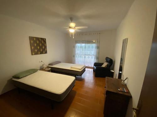 um pequeno quarto com 2 camas e uma cadeira em Villa Fortuna em Alcanar