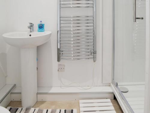 y baño blanco con lavabo y ducha. en Hives - W43108, en Bradworthy
