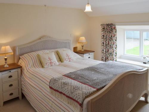 a bedroom with a bed and a window at Blackhill Gate Cottage in Taxal