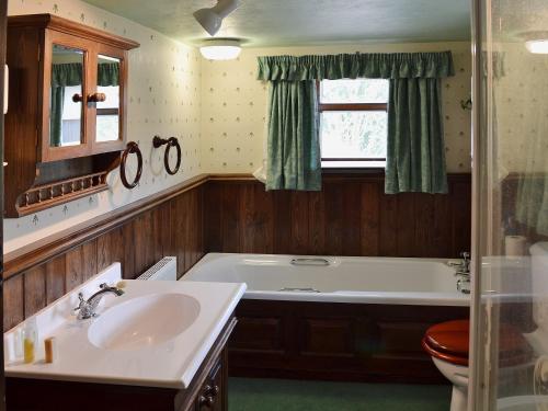 a bathroom with a sink and a bath tub at Blackhill Gate Cottage in Taxal