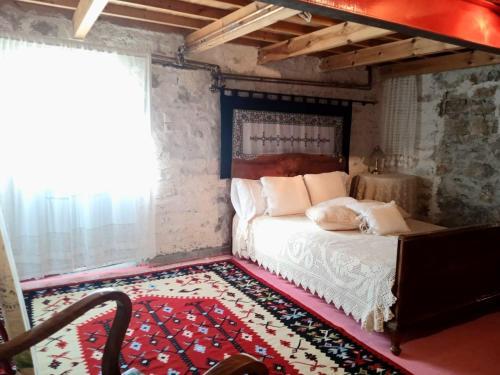 a bedroom with a bed and a red rug at Alexadras Guesthouse in Ampelochórion