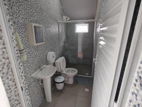 a small bathroom with a toilet and a sink at Chalé Arizona in São Roque