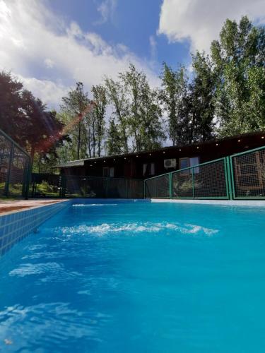 uma grande piscina azul num quintal em Cabañas Berta y Jorge em Cacheuta