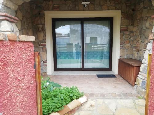 a glass door of a house with a stone wall at B&B Acquamarina Villasimius in Villasimius