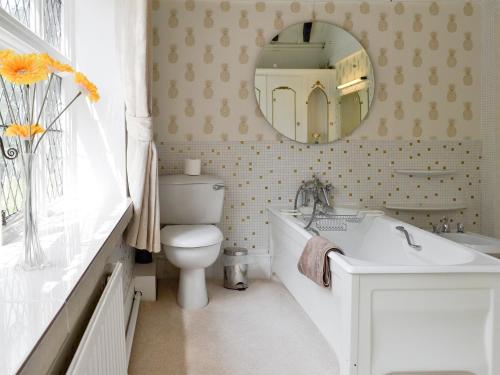 a bathroom with a sink and a toilet and a mirror at The Sanctuary in Little Chart