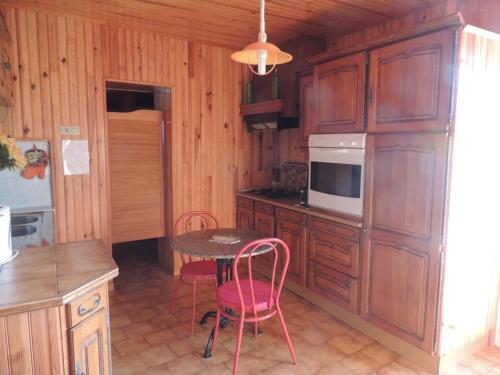 une cuisine avec des armoires en bois et une table et des chaises dans l'établissement Campagne peygros, à Pierrefeu-du-Var
