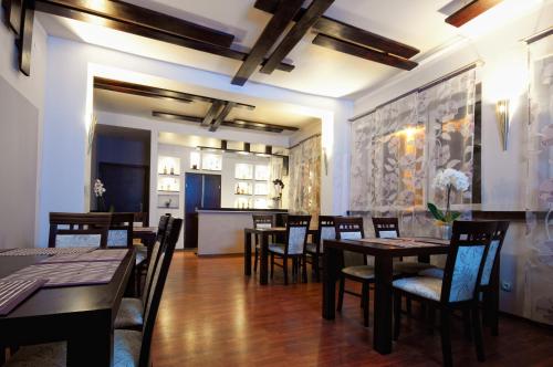 a dining room with tables and chairs and a kitchen at Hotel-24 in Płock