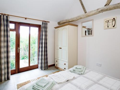 a bedroom with a bed and a window at Thyme - E4485 in Ludham