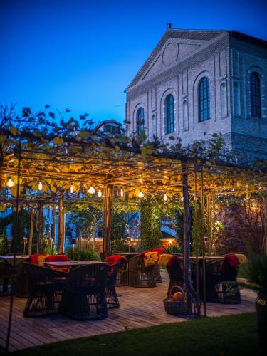 a patio with tables and chairs in front of a building at Madama Garden Retreat in Venice