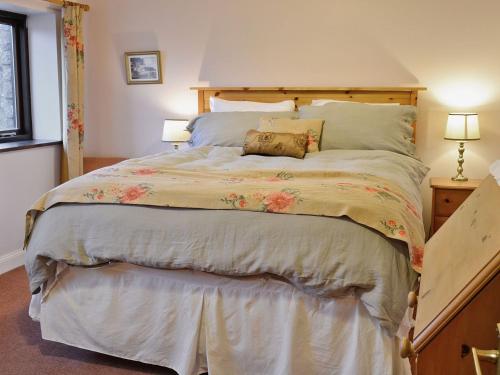 a bedroom with a large bed with a wooden headboard at Cranesbill Barn in Ravenstonedale