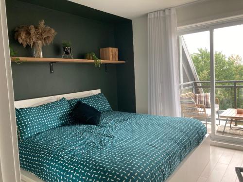 a bed with a blue comforter in a bedroom at Le Haven in MSA in Beaupré