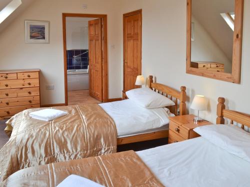 1 dormitorio con 2 camas y espejo en The Stables, en Somersal Herbert