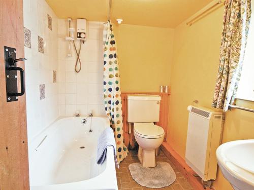 een badkamer met een bad, een toilet en een wastafel bij The Granary - Hw7187 in Henrys Moat