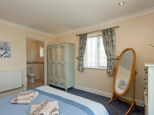 a bedroom with a bed and a mirror at Puddle Inn Duck in Horning