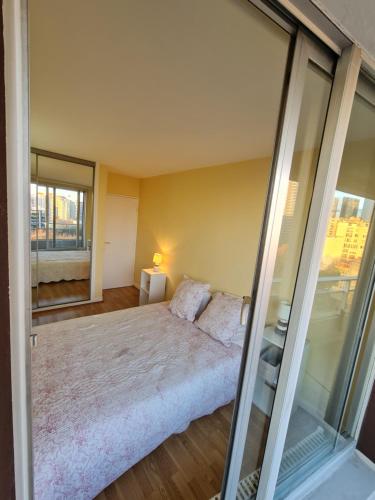 um quarto com uma cama grande e paredes de vidro em chambre privée em Puteaux