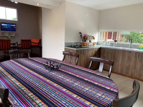 una cocina con una mesa con una alfombra colorida en MY HOUSE IN MACAS, en Macas