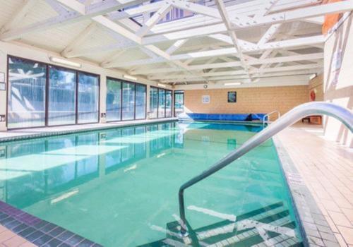 a large indoor swimming pool with a swimming pooliteratorhaarhaarhaarythonythonython at Bayside Resort, Ascend Hotel Collection in Parksville