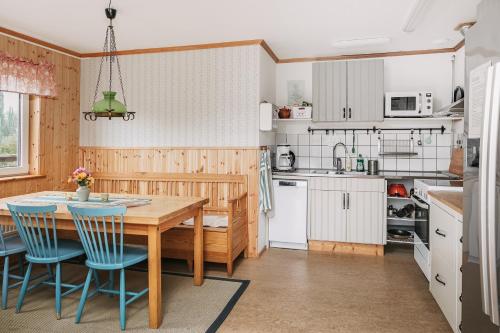 cocina con mesa de madera y sillas azules en STF Lugnåsberget Ekohotell, en Mariestad