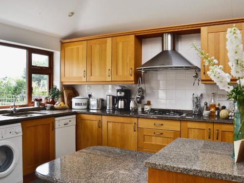 a kitchen with wooden cabinets and a stove top oven at Endeavours End in Gatehouse of Fleet