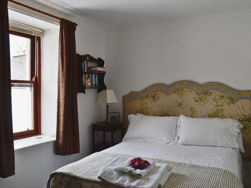 Un dormitorio con una cama con una bandeja de flores. en Endeavours End, en Gatehouse of Fleet