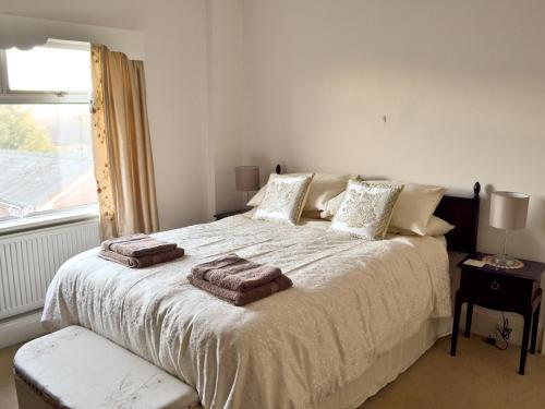 ein Schlafzimmer mit einem großen Bett mit zwei Handtüchern darauf in der Unterkunft Marstan House in Standish
