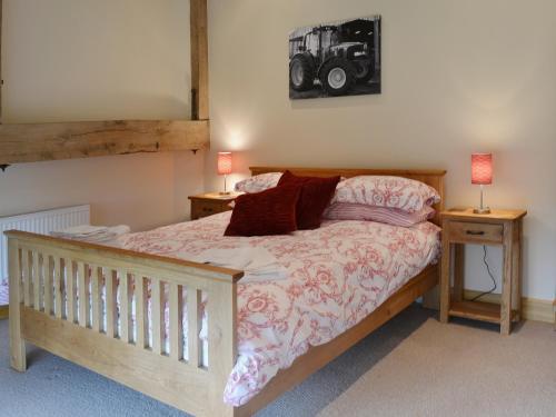 a bedroom with a bed with two night stands and two lamps at The Old Workshop in Alderminster