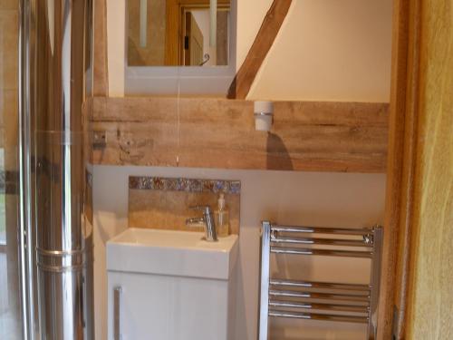 uma pequena casa de banho com um lavatório e um espelho em The Old Workshop em Alderminster