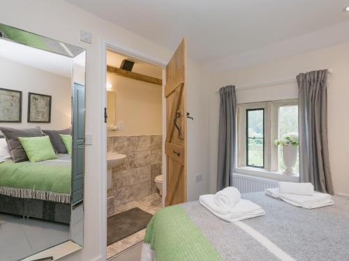 a bedroom with a bed and a mirror at Hall Cottage in Brampton