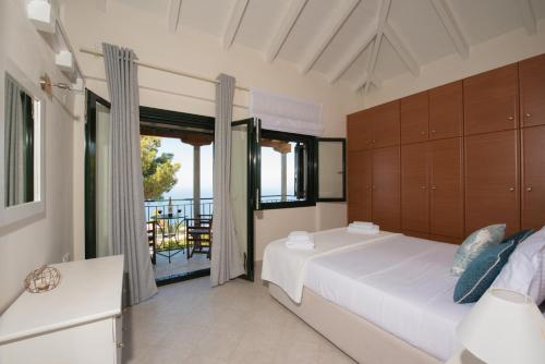 a bedroom with a large bed and a balcony at Villa Endless Blue in Kalamitsi