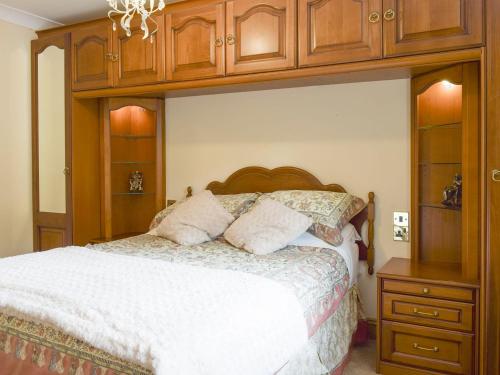 a bedroom with a bed with a wooden canopy at No 2 Pegraig Draw - Uk6435 in Llanychaiarn