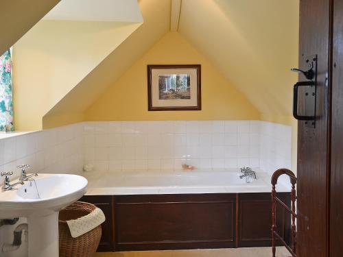 a bathroom with a large tub and a sink at Mill Cottage in Mathon