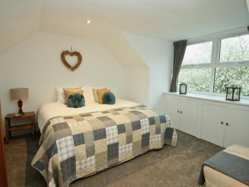 a bedroom with a bed with a checkered blanket at Mackenzie Cottage in Poolewe