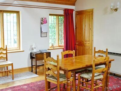 comedor con mesa de madera y sillas en Netherall Manor Lodge en Soham