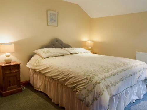 PillingにあるWest Boundary Farm Cottage 2のベッドルーム1室(ベッド1台、テーブルの上にランプ2つ付)