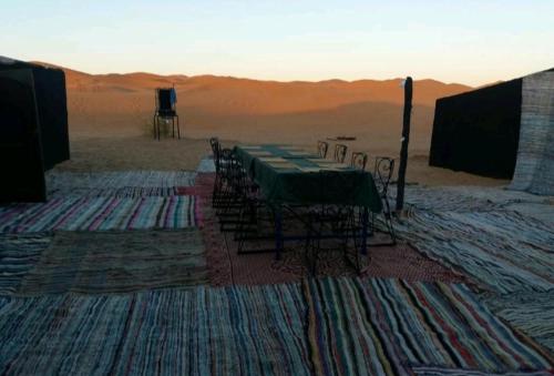 a group of tables and chairs in the desert at BerberNightCamp in Adrouine