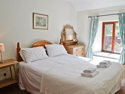 a bedroom with a bed with two towels on it at 1 Oaks Farm Cottages in Ambleside