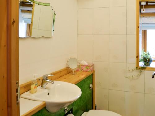 W łazience znajduje się umywalka, toaleta i lustro. w obiekcie Sparrows w mieście Morvah