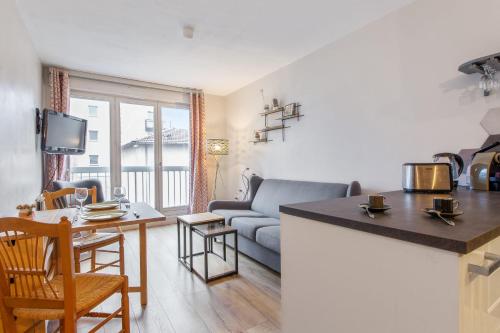 une cuisine et un salon avec un canapé et une table dans l'établissement Appartement de Montplaisir - Welkeys, à Lyon